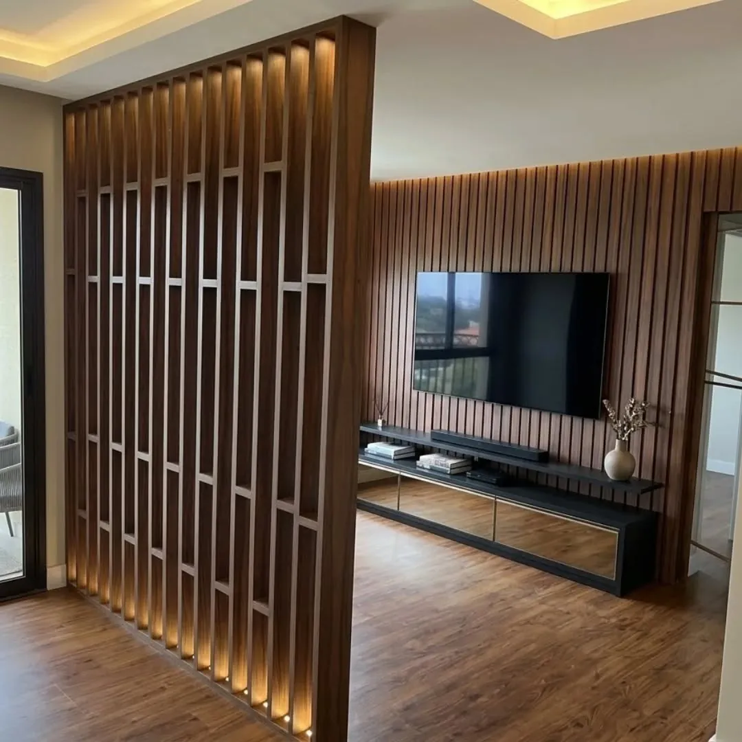 Sala com painel ripado iluminado, divisória de ripas e TV